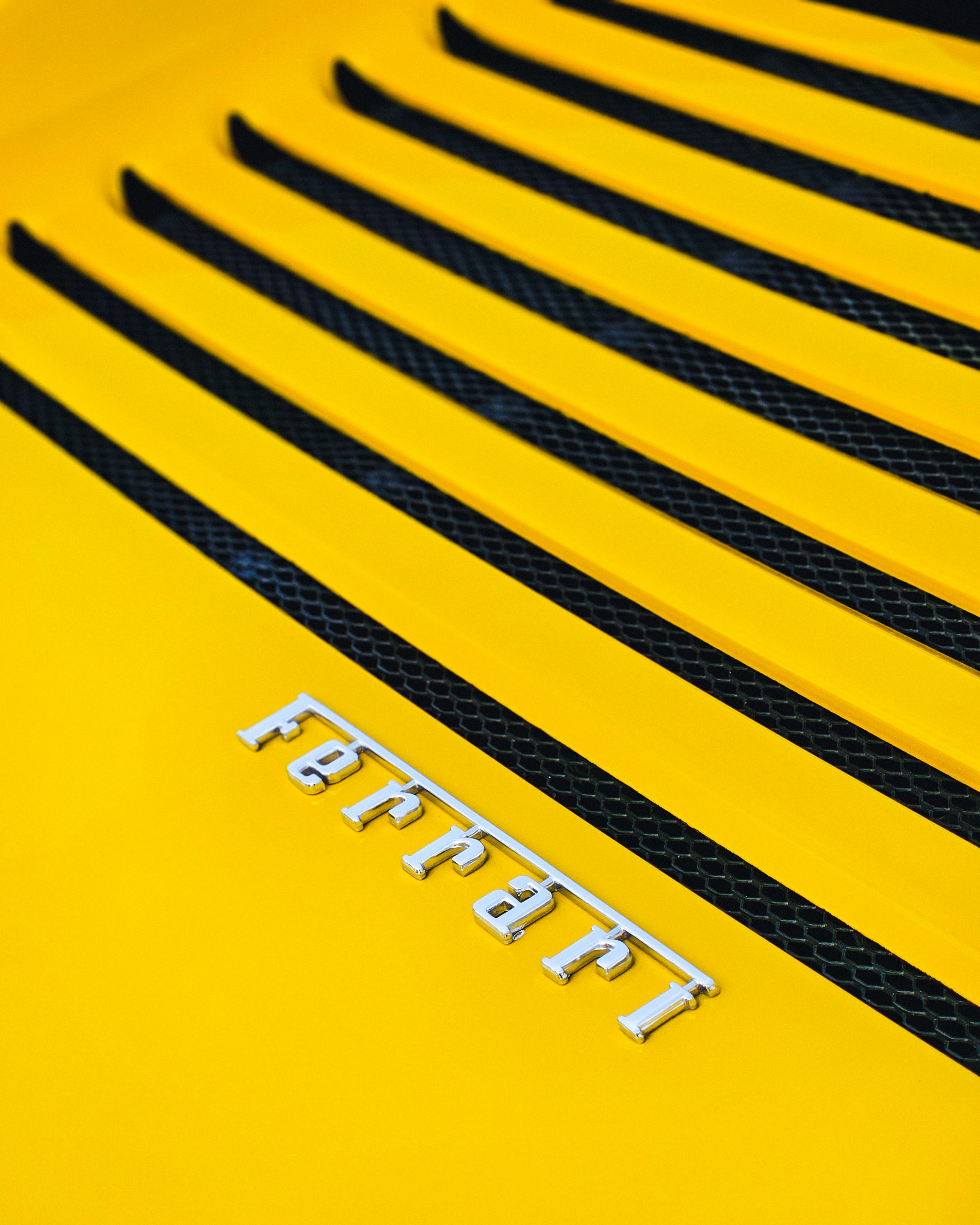 a close up of the hood of a yellow sports car